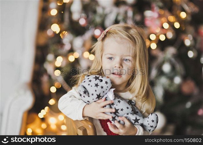 Beautiful child in anticipation of the new year.. A little girl sitting near Christmas tree in expectation of a miracle 7314.