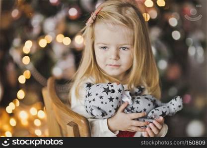 Beautiful child in anticipation of the new year.. A little girl sitting near Christmas tree in expectation of a miracle 7318.