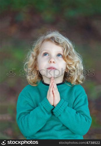 Beautiful child praying with his hands toguether