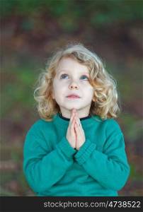 Beautiful child praying with his hands toguether