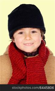 Beautiful child with wool scarf isolated on a yellow background