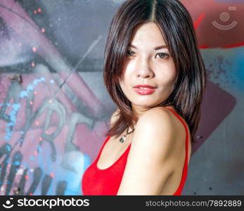 Beautiful Chinese woman by walls filled with graffiti