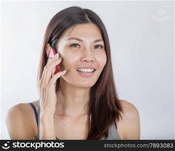 Beautiful Chinese woman talking on smartphone happily