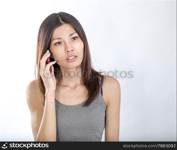 Beautiful Chinese woman talking on smartphone, looking concerned