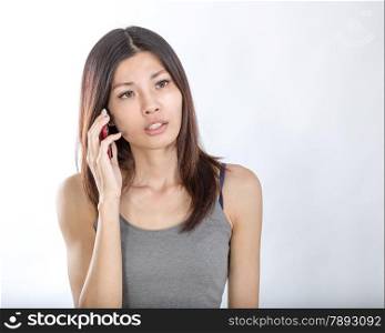 Beautiful Chinese woman talking on smartphone, looking concerned