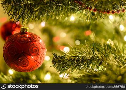 Beautiful Christmas background - red baubles on a background of blurred lights on a Christmas tree with bokeh effect.