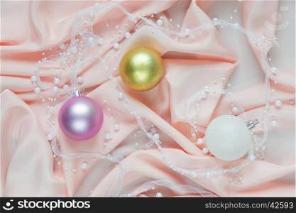 Beautiful Christmas composition with Christmas balls on a pink folded silk. Flat lay composition for greeting cards, websites, social media, magazines, bloggers, artists etc. Christmas wallpaper