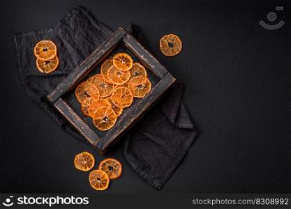 Beautiful Christmas decoration consisting of an old wooden box with dried citrus fruits on a dark concrete background