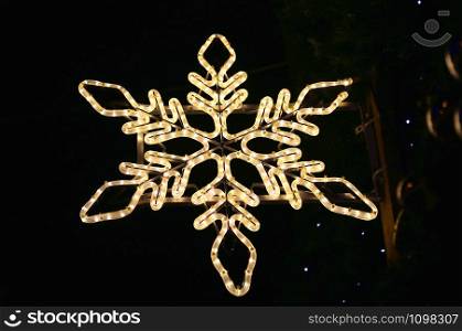 Beautiful christmas decoration on the streets of Europe, bright glowing neon snowflake