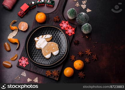 Beautiful Christmas decorations with holiday toys, clementines and gingerbread on a dark concrete background. Preparing the Christmas table. Beautiful Christmas decorations with holiday toys, clementines and gingerbread