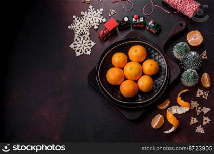 Beautiful Christmas decorations with holiday toys, clementines and gingerbread on a dark concrete background. Preparing the Christmas table. Beautiful Christmas decorations with holiday toys, clementines and gingerbread