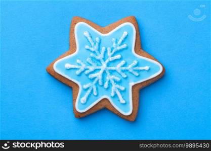 Beautiful christmas gingerbread cookie in shape of star with snowflake over blue background