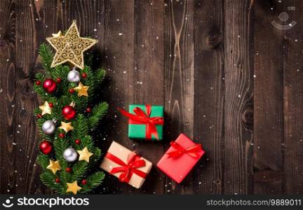 Beautiful Christmas green tree fresh fir branches and ornaments gift box and the star in-studio shot on black wooden background with copy space, New year card concept