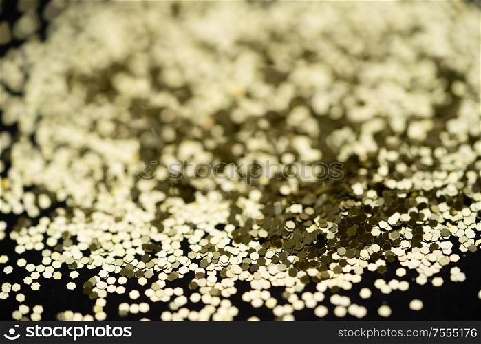 Beautiful Christmas light background. Abstract ?????? glitter bokeh and scattered sparkles, on black. Beautiful Christmas light background. Abstract glitter bokeh and scattered sparkles in gold, on black