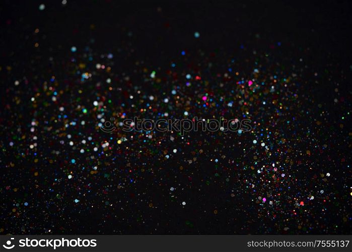 Beautiful Christmas multicolored light background. Abstract multicolored glitter bokeh and scattered sparkles , on black. Beautiful Christmas light background. Abstract glitter bokeh and scattered sparkles in gold, on black