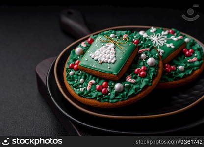 Beautiful Christmas or New Year colorful homemade gingerbread cookies on a ceramic plate on a dark concrete background. Beautiful Christmas or New Year colorful homemade gingerbread cookies