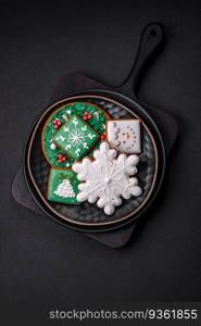 Beautiful Christmas or New Year colorful homemade gingerbread cookies on a ceramic plate on a dark concrete background. Beautiful Christmas or New Year colorful homemade gingerbread cookies