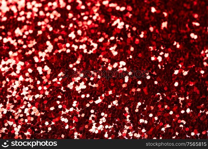 Beautiful Christmas red light background. Abstract glitter bokeh and scattered sparkles in gold, on black. red glitter bokeh background