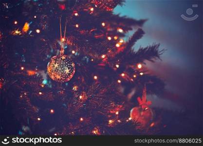 Beautiful Christmas tree in dark evening light with festive xmas lights on it, cozy family holiday at home, happy winter holidays
