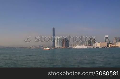 Beautiful cityscape of Hongk Kong over Victoria Harbour on a sunny day. Amazing panorama of buildings and blue sky. View of city skyline with skyscrapers by Victoria Harbour. Hong Kong, November 9, 2017.