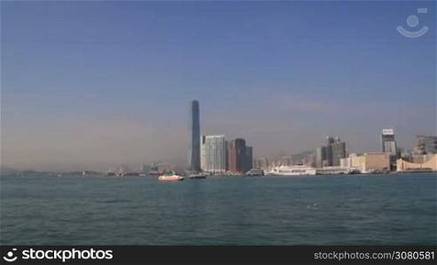 Beautiful cityscape of Hongk Kong over Victoria Harbour on a sunny day. Amazing panorama of buildings and blue sky. View of city skyline with skyscrapers by Victoria Harbour. Hong Kong, November 9, 2017.