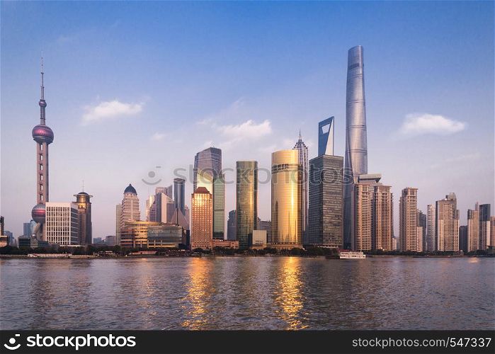 Beautiful cityscape with glass skyscrapers standing along the Huangpu River against the backdrop of the setting sun.. Beautiful cityscape with glass skyscrapers standing along the Huangpu River against the backdrop of the setting sun