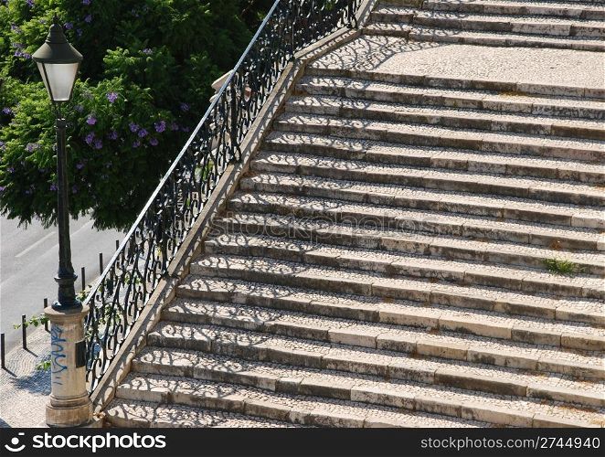 beautiful close up of a typical stairway made of calcada pavement with a gorgeous retro lamp post