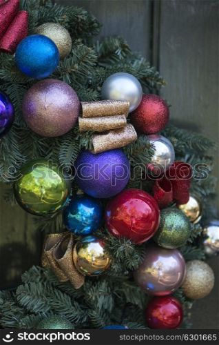 Beautiful close up of old fashioned retro vintage style Christmas wreath hanging on wooden door