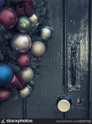 Beautiful close up of old fashioned retro vintage style Christmas wreath hanging on wooden door