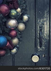 Beautiful close up of old fashioned retro vintage style Christmas wreath hanging on wooden door