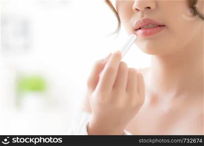 Beautiful closeup young asian woman applying makeup lipstick in the room, beauty lips asia girl makeup and cosmetic fashion on mouth at home, lifestyle and health care concept.