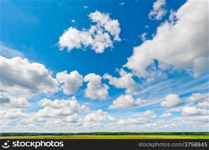 beautiful clouds and blue sky over field and fores