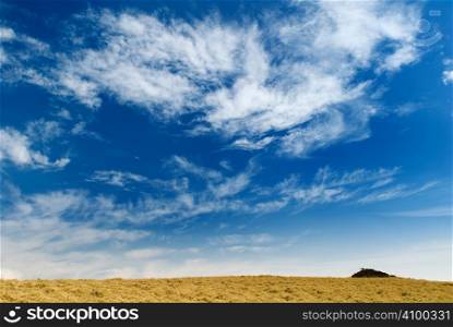 Beautiful clouds over the golden grassland in mountain.