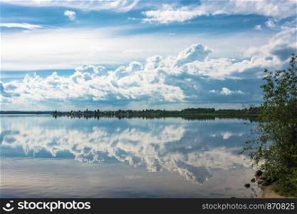 Beautiful clouds over the mirror-like surface of the lake on a summer day, Karelia, Russia