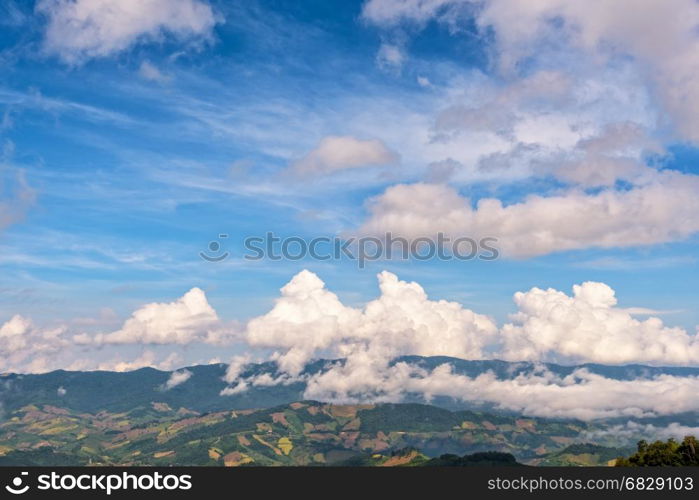 Beautiful cloudscape and blue sky above the high mountain range, There are hillside farming in Chiang Rai Province, Northern Thailand