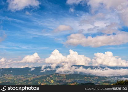 Beautiful cloudscape and blue sky above the high mountain range, There are hillside farming in Chiang Rai Province, Northern Thailand