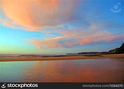Beautiful cloudscape at Praia Vale Figueiras in Portugal at sunset