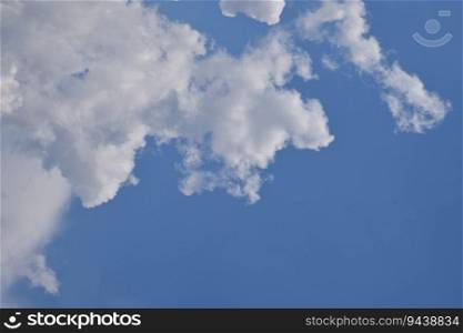Beautiful cloudscape with bright white clouds over blue sky, low angle view