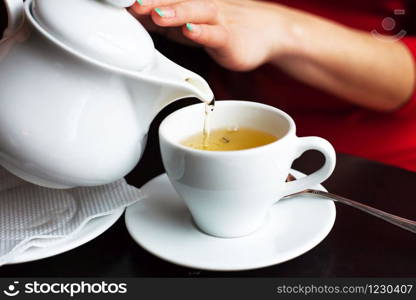 beautiful coffee house in an interesting cozy design-the girl pours herself a tea.. beautiful coffee house in an interesting cozy design-the girl pours herself a tea