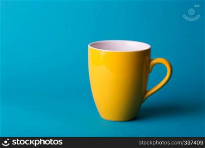 beautiful coffee yellow cup on blue background