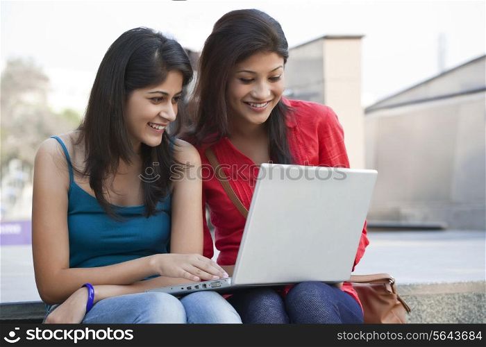 Beautiful college students using laptop