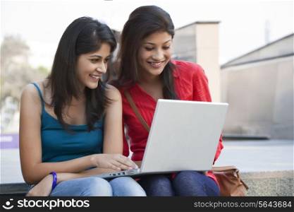 Beautiful college students using laptop