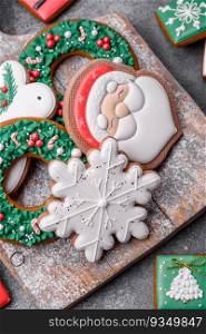 Beautiful colored Christmas gingerbread cookies for the design and decoration of the festive table on a textured concrete background