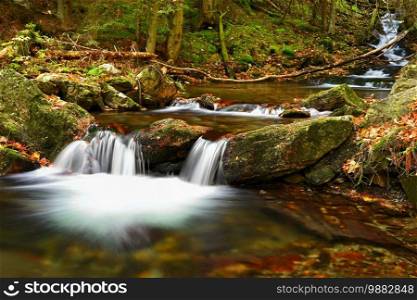 Beautiful colorful background with river and stones in autumn time. White Opava Waterfalls - Jeseniky Mountains - Czech Republic.