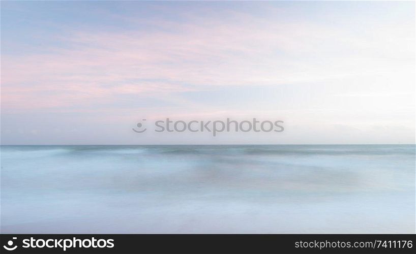 Beautiful colorful landscape image of blurred waves at sunset in Devon Enlgand