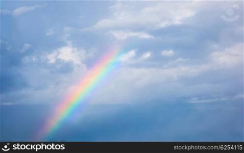 Beautiful colorful rainbow in cloudy sky, abstract background, natural phenomenon, bright multicolors sun beam after rain, meteorology concept