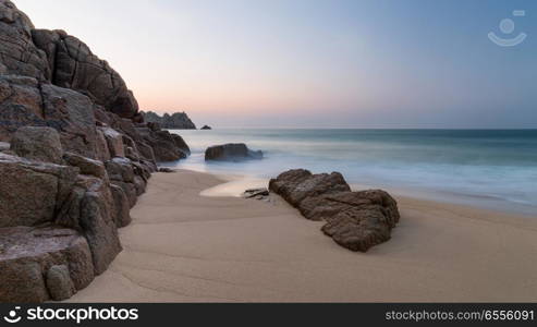 Beautiful colorful sunrise landscape image of Porthcurno beach on South Cornwall coast in England