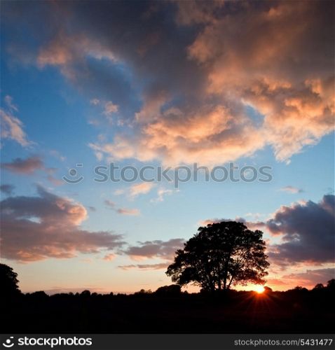 Beautiful colorful sunset in Summer over fields with lovely deep colors