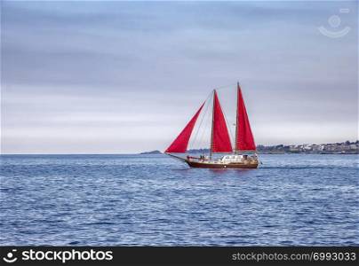 Beautiful composition and mood of a sailing sailboat with red sails