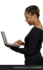Beautiful computer savvy young black woman using a laptop . Sunset over a Lake